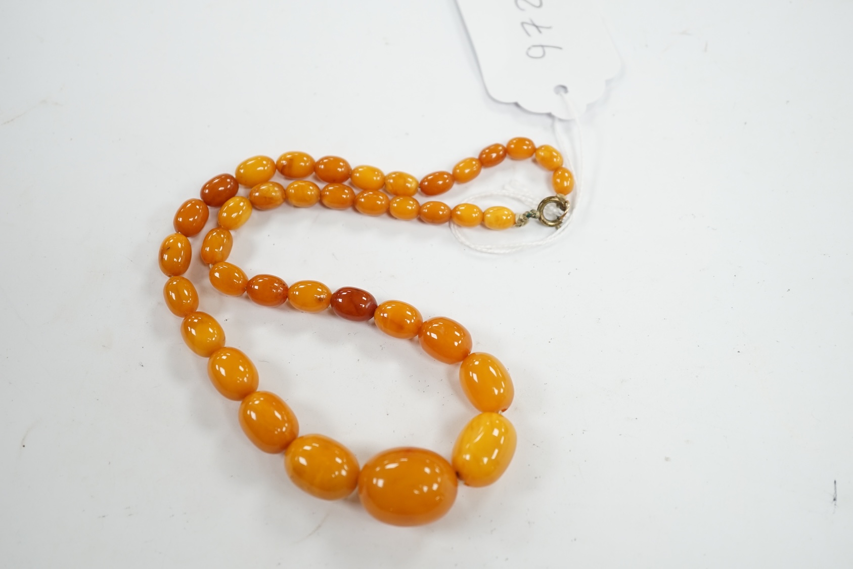 A single strand graduated oval amber bead necklace, 42cm, gross weight 23 grams. Condition - poor to fair